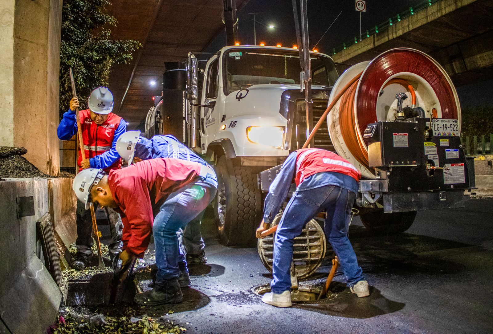 Équipe insérant une ligne d'inspection dans un drain par un accès extérieur