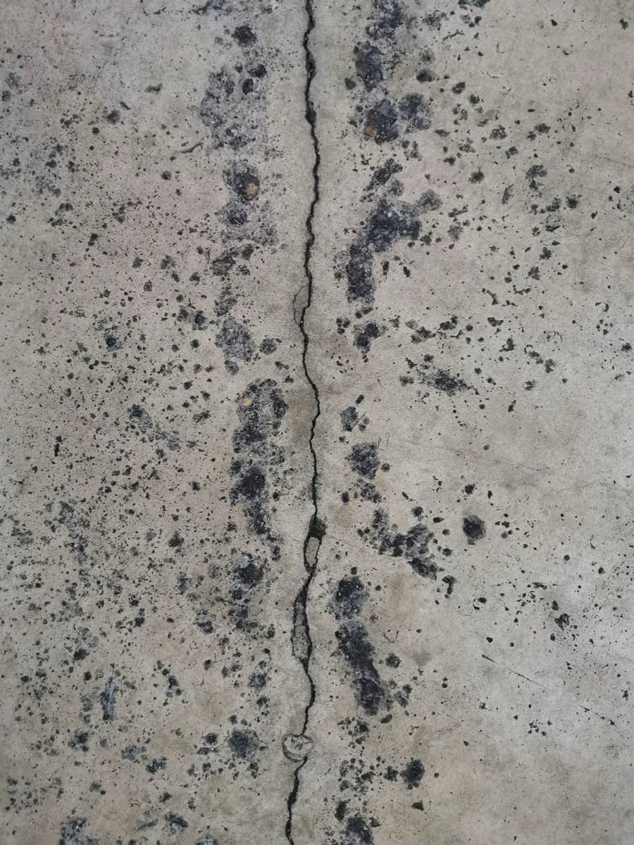 Fissure fine traversant une dalle de béton de sous-sol