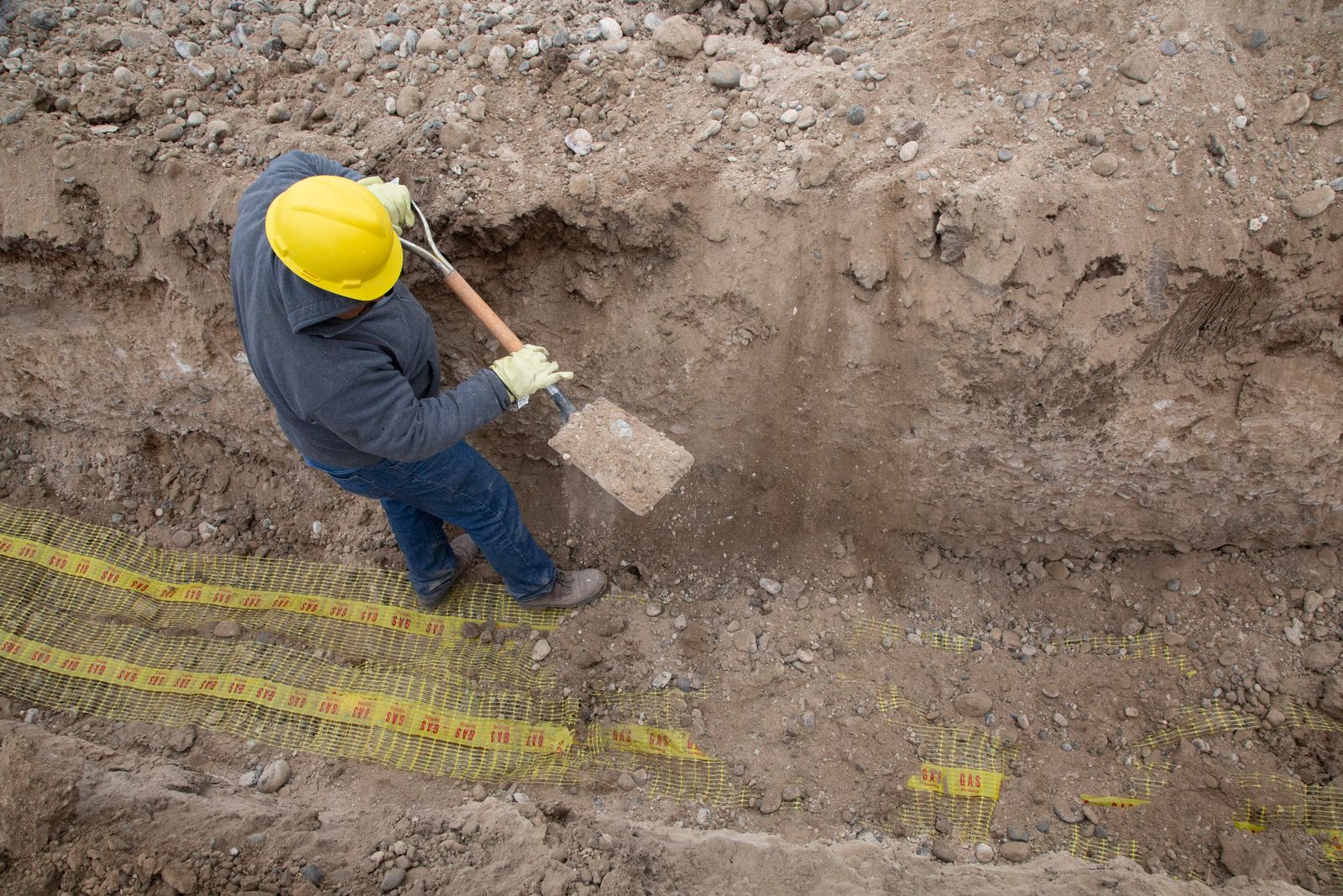 Technicien travaillant dans une tranchée d'excavation le long d'une fondation